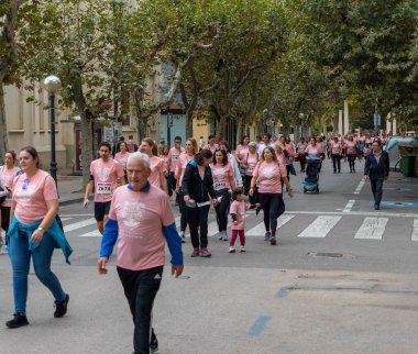 22 Ekim 2022 'de Huesca şehrinde göğüs kanserine karşı yarışan koşucular göğüs kanserine katılan mutlu kadınların park portresinde finiş çizgisini geçerek tezahürat yaptılar.