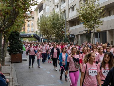 22 Ekim 2022 'de Huesca şehrinde göğüs kanserine karşı yarışan koşucular göğüs kanserine katılan mutlu kadınların park portresinde finiş çizgisini geçerek tezahürat yaptılar.