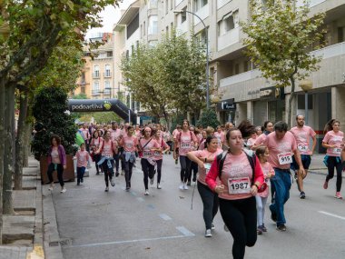 22 Ekim 2022 'de Huesca şehrinde göğüs kanserine karşı yarışan koşucular göğüs kanserine katılan mutlu kadınların park portresinde finiş çizgisini geçerek tezahürat yaptılar.