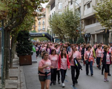 22 Ekim 2022 'de Huesca şehrinde göğüs kanserine karşı yarışan koşucular göğüs kanserine katılan mutlu kadınların park portresinde finiş çizgisini geçerek tezahürat yaptılar.