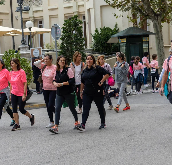 22 Ekim 2022 'de Huesca şehrinde göğüs kanserine karşı yarışan koşucular göğüs kanserine katılan mutlu kadınların park portresinde finiş çizgisini geçerek tezahürat yaptılar.