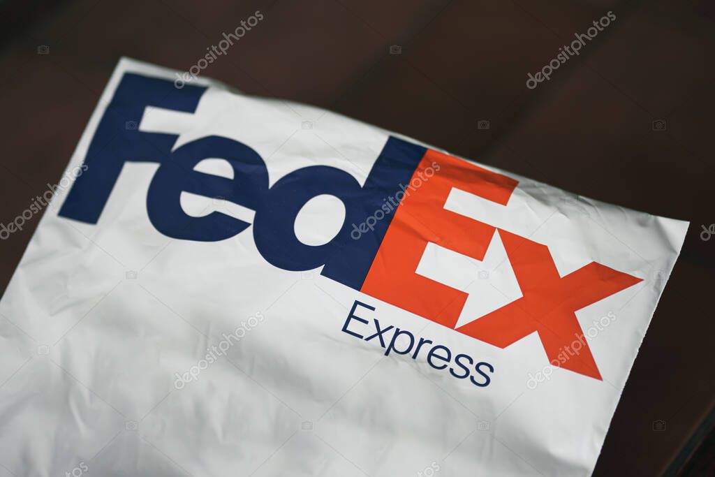 FedEx Express parcel. Lifestyle picture of the FedEx shipping bag on dark table background