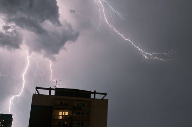 Şehirde şimşek çakıyor. Fırtınadan dolayı aşırı hava koşulları. Şiddetli sağanaklı dramatik gökyüzü.