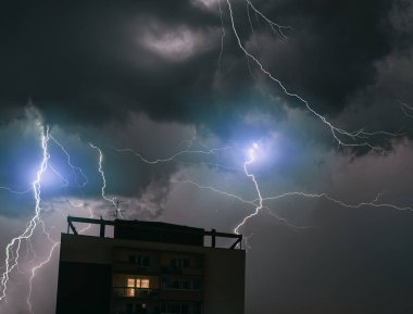 Şehirde şimşek çakıyor. Fırtınadan dolayı aşırı hava koşulları. Şiddetli sağanaklı dramatik gökyüzü.