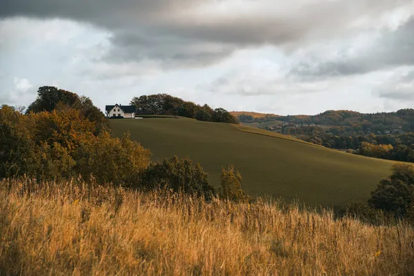 現代の家は丘の上に立っている 高い地面の上に家と風景風景 — ストック写真