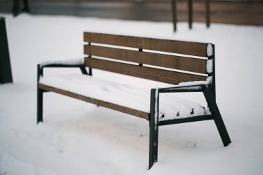 Karla kaplı bir bank. Şehir parkı kışın boş tezgah. Karla kaplı boş kentsel bölge kavramı.