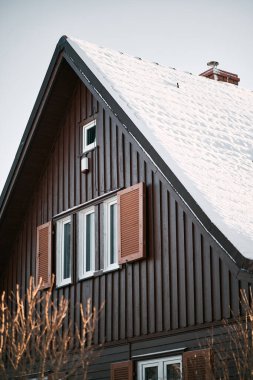 Karla kaplı ahşap ev çatısı. Evde geçirilen Noel tatili kavramı