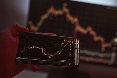 İşadamı akıllı telefon kullanarak borsa verilerini kontrol ediyor. Analiz ekonomisi verileri kavramı ve kripto zinciri pazar platformu ticareti