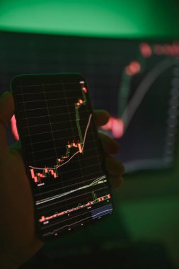 İşadamı akıllı telefon kullanarak borsa verilerini kontrol ediyor. Analiz ekonomisi verileri kavramı ve kripto zinciri pazar platformu ticareti