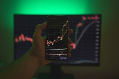 İşadamı akıllı telefon kullanarak borsa verilerini kontrol ediyor. Analiz ekonomisi verileri kavramı ve kripto zinciri pazar platformu ticareti