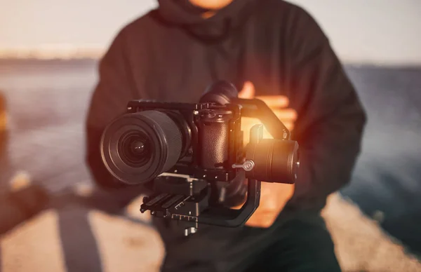 男は手に安定したジンバルを持ったカメラを持っている 若い独立系映画作家のコンセプトは — ストック写真