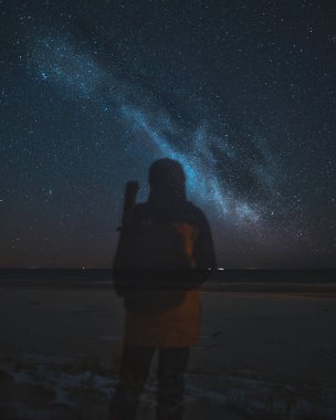Yıldızları izleyen ve Samanyolu Galaksilerini keşfeden insanlar. Yıldızlarla dolu bir gece gökyüzünün uzun pozlama fotoğrafı. Yüzü olmayan bir insanın silueti. Genç insanların parlak bir gelecek hayal etmesi kavramı.