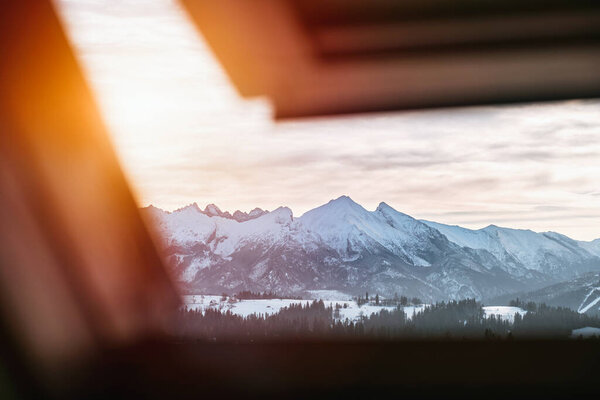 Mountain vista from the roof window view. Panorama of Tatry mountains with strong sunlight