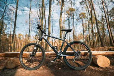 Mountain bike in the woods. A bicycle with sports geometry and air fork stands in the forest. Concept of spending time doing extreme sports outside