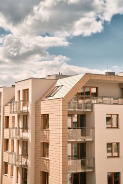 Gün batımında apartmanda. Akşamları apartman inşaatı var. Düşük seviyeli modern konut binasına güçlü güneş ışığı düşüyor.