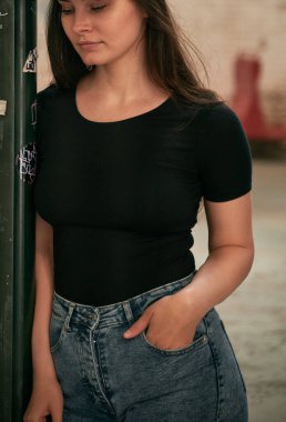 Siyah tişört giyen bir kızın boş bir reklam modeli. Günlük giysiler için tasarımcı şablonu