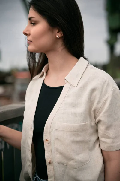 Gorgeous brunette girl wearing a light linen shirt over a black t-shirt. Cloth line advertising mock-up. No logo streetwear