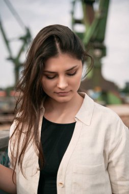 Siyah bir tişörtün üzerine açık keten gömlek giyen güzel esmer kız. Kumaş markası reklam modeli. Logo sokak kıyafeti yok.