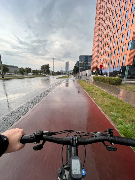 POV of a bike commuting downtown during rainy weather. Well-built bicycle infrastructure in Europe concept.