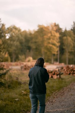 Kadın sonbahar ormanında yürüyor. Eylülde ormanda tek başına dolaşmak..