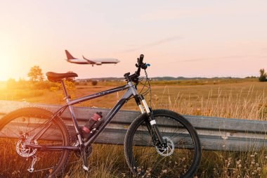 Bicycle stands in front of a landing plane