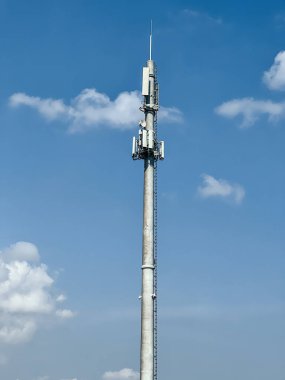 Macro Base Station. 5G radio network telecommunication equipment with radio modules and smart antennas mounted on a metal against cloulds sky background. Telecommunication tower of 4G and 5G cellular.