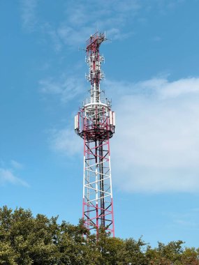 Macro Base Station. 5G radio network telecommunication equipment with radio modules and smart antennas mounted on a metal against cloulds sky background. Telecommunication tower of 4G and 5G cellular.