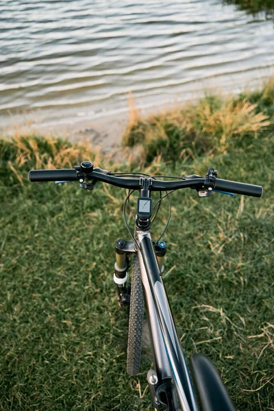 POV bike handlebar with a nature backdrop. Leisure time in summer evening concept.