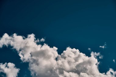 Single white cloud in the blue sky. Background texture of a summer sky.