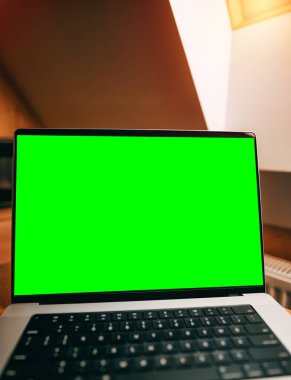 Uzaktan çalışma ve içeride dizüstü bilgisayar kullanma kavramı. Tahta bir masada dizüstü bilgisayar, boş bir bilgisayar ekranı. İskandinav iç ve çatı penceresi.