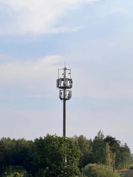 Macro Base Station. 5G radio network telecommunication equipment with radio modules and smart antennas mounted on a metal against cloulds sky background. Telecommunication tower of 4G and 5G cellular.