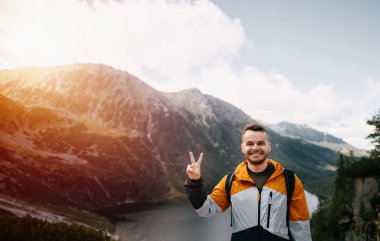 Dağlardan, göllerden ve ormanlardan oluşan güzel bir geçmişi olan beyaz bir adam yürüyüş yapıyor. Dağlarda aktif boş zaman kavramı.