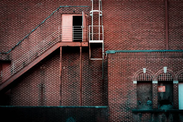 Demir yangın merdiveni ve deniz mavisi süslemeli huş ağacı cephesi.