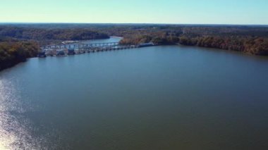 Great Falls, SC 'deki Catawba Nehri' ndeki baraj ve otoyol üstgeçidine doğru hava saldırısı. Sonbaharın geç saatlerinde yeşillik ve açık mavi gökyüzüyle.