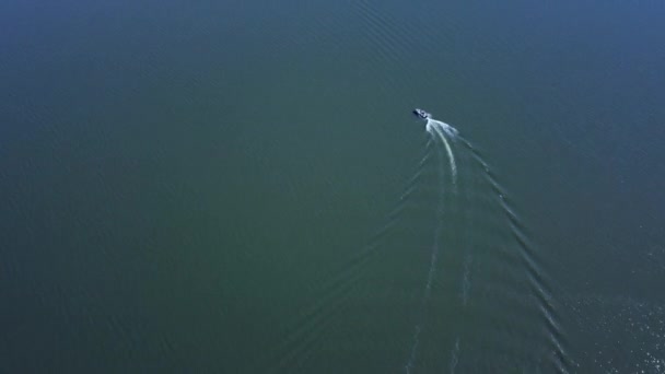 広い弧を描くように開いている淡水湖上の小さなボートに続く空中 — ストック動画