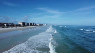 Güneşli Florida 'da güzel mavi suların ve köpüklü kumların üzerinde uçuyor.