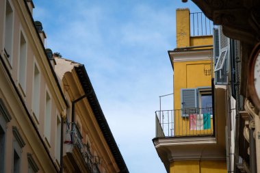Roma 'daki apartman balkonunda asılı duran yıpranmış İtalyan ulusal bayrağı..