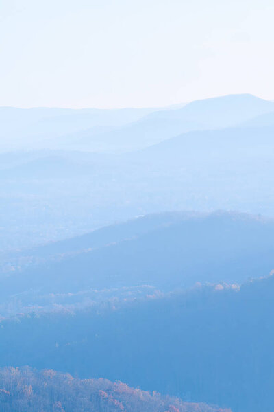 Forest covered hills in the mountains of North Carolina with much mist and partially hidden layers.