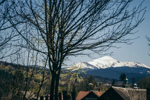 Snow-capped mountain on the horizon, and mountain villages — Stock Photo, Image