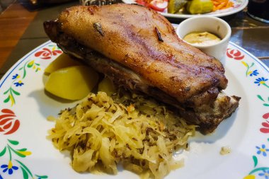 Kavrulmuş domuz knuckle eisbein kızarmış haşlanmış lahana ve hardal ahşap kesme tahtası üzerinde