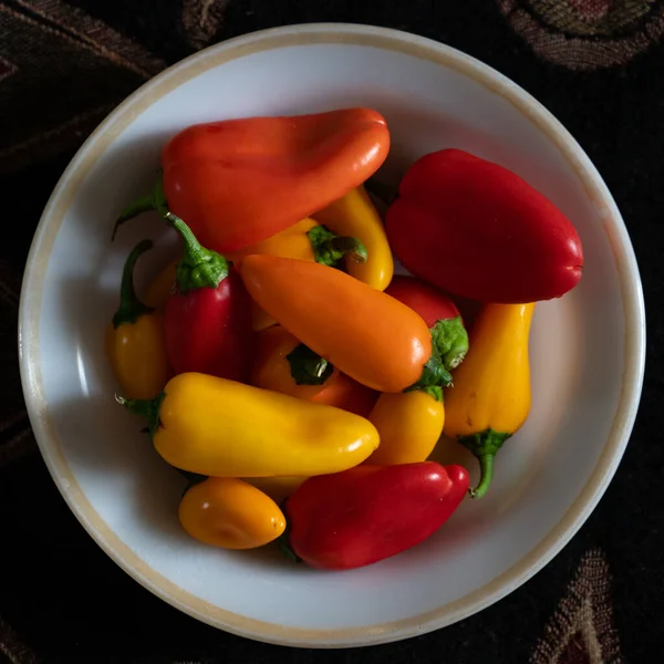 Plate with ripe paprika peppers on a dark background,top view. — Stock Photo, Image