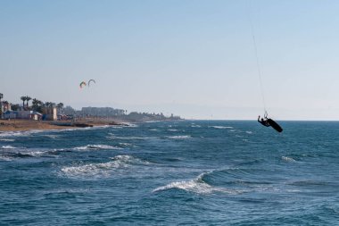 Nahariya 'nın gezinti güvertesi ve Galei Galil Sahili' nin rıhtım manzarası. Uzaklarda yelkenli tekneler ve uçurtmacılar.