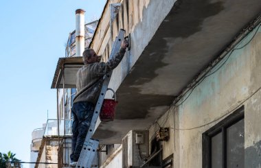 TEL AVIV, ISRAEL - 25 Ocak 2022: Yona HaNavi Caddesi Bir adam bir evi onarıyor.