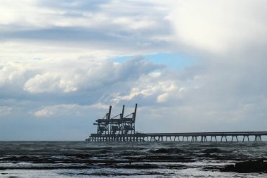 Konteynırları gemiden gemiye yüklemek ve yüklemek için vinçleri olan açık deniz terminali..