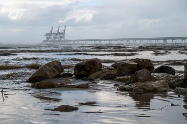 Konteynırları gemiden gemiye yüklemek ve yüklemek için vinçleri olan açık deniz terminali..