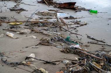 Kumsal kirliliğine yakın. Çöp plastiği, şişeler, tropikal denizden gelen gereksiz diğer çöpler kıyıya vurmuş. Seçici odaklanma. Ekolojik kavram. Yakın plan..