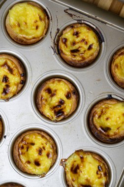 Yumurtalı tart, geleneksel Portekiz tatlısı, pastel de nata. Taze pişmiş. Fırından yeni çıkmış bir çarşaf uzanıyor..