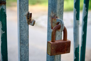 Kapılar kırılarak açılmış ve bir yaprağın üzerinde kapalı bir asma kilit var. Yakın plan..