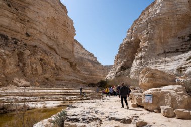 CANYON EIN AVDAT, ISRAEL - 5 Mart 2022: İsrail 'deki Negev Çölünde Kanyon Ein Avdat' ta yürüyen turistler.