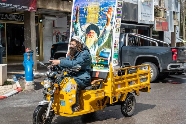 SAFED, ISRAEL - 25 Mart 2022: Beyaz kippah 'lı dindar bir adam üç tekerlekli sarı bir bisikletle güvenli, İsrail' de geziyor.